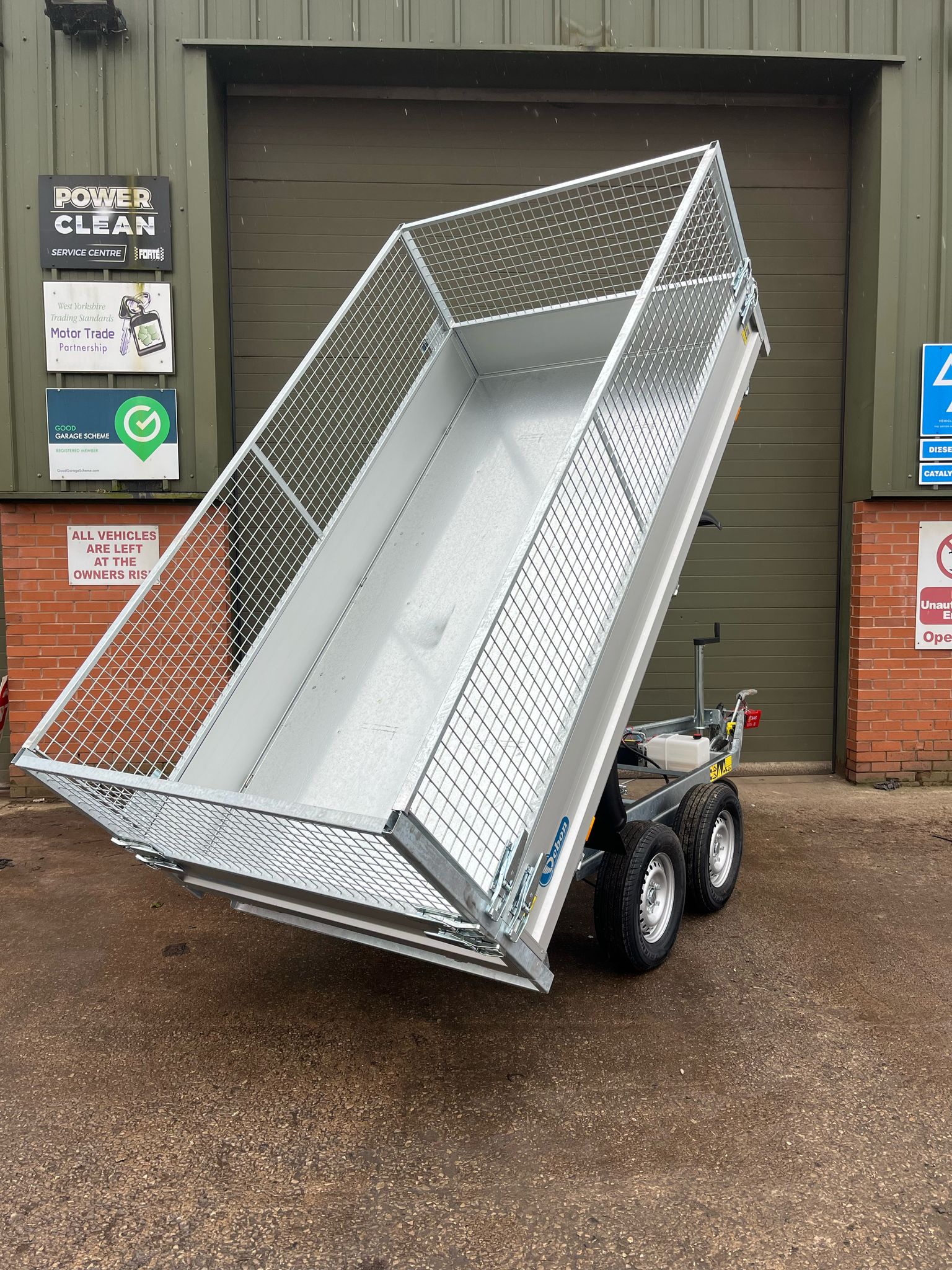 Debon PW1.2 electric tipping trailer with mesh sides, tipped up.