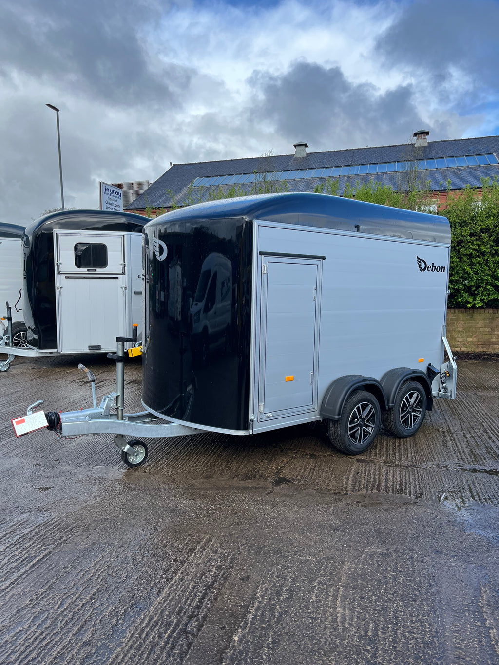 Debon C500 side view with alloy wheels and side access door, black roof front and aluminium sides.